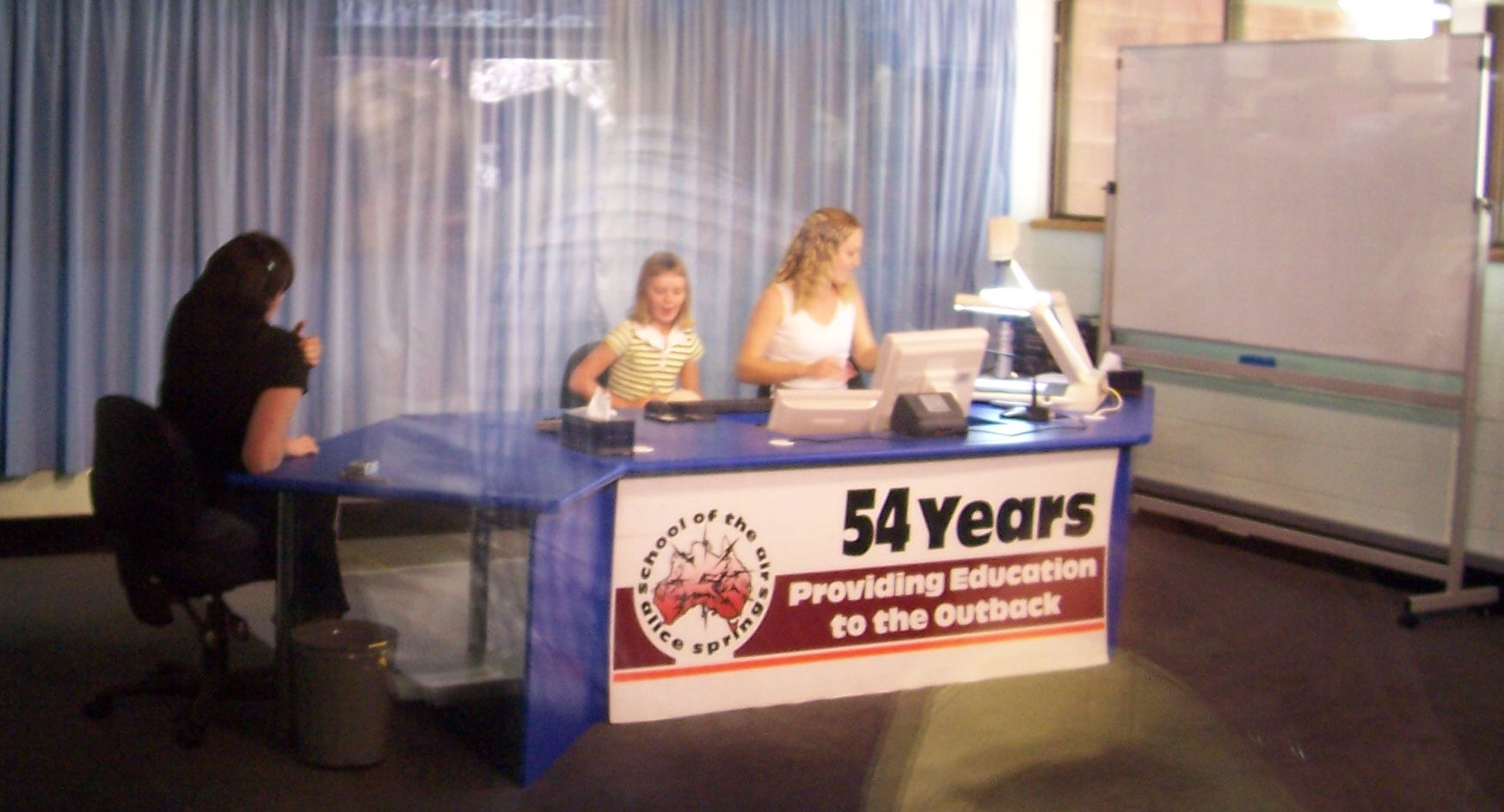 Zwei Frauen und ein junges Mädchen in einem Studio der School of the air.
