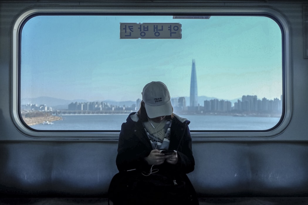 Mädchen in U-Bahn mit Ausblick auf Gangnam im Hintergrund