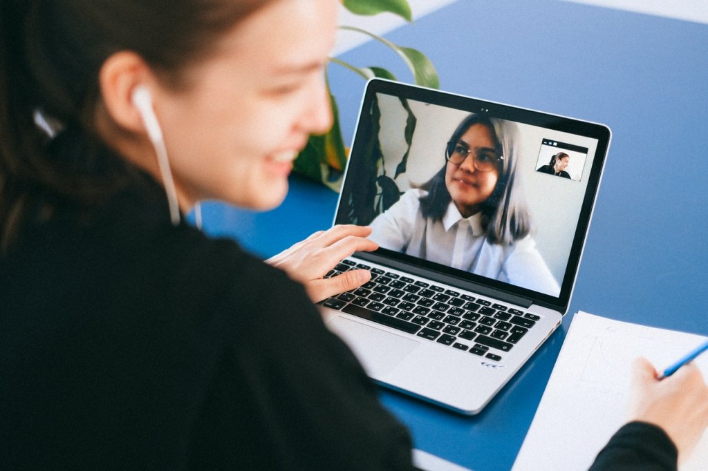 Young woman in front of a laptop with a running video call