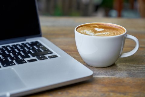 Kaffeetasse neben Laptop