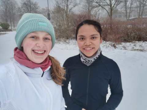 Zwei Studentinnen im Schnee beim gemeinsamen Lauftandem.