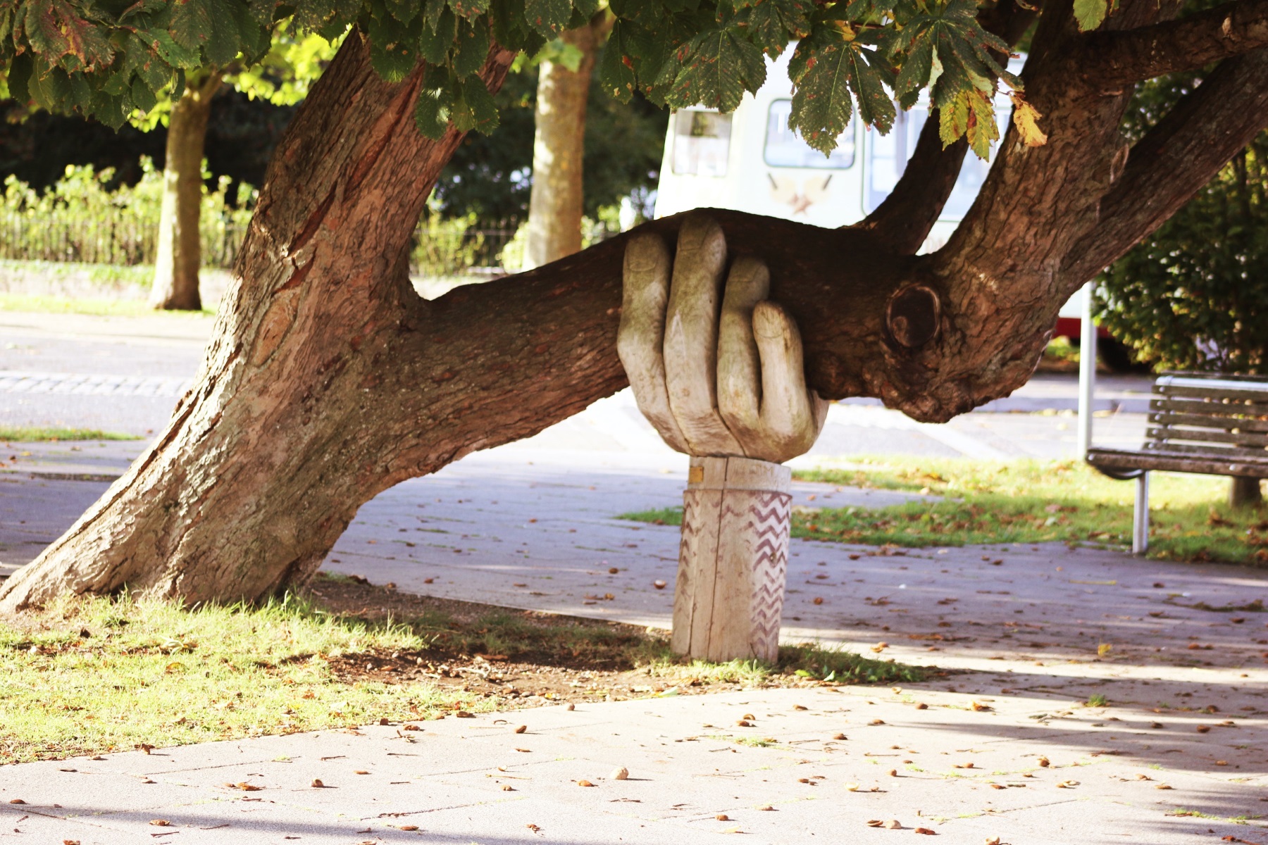 Statue of an arm holding a tree.