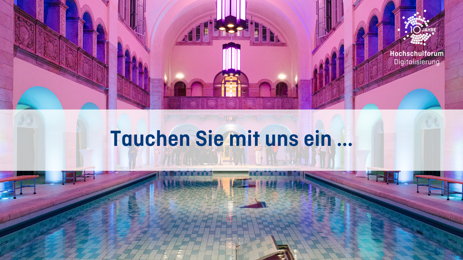 HFDcon: Blick in die Veranstaltungslocation Stadtbad Oderberger mit Swimming Pool mit dem Schriftzug "Tauchen Sie mit uns ein ...".