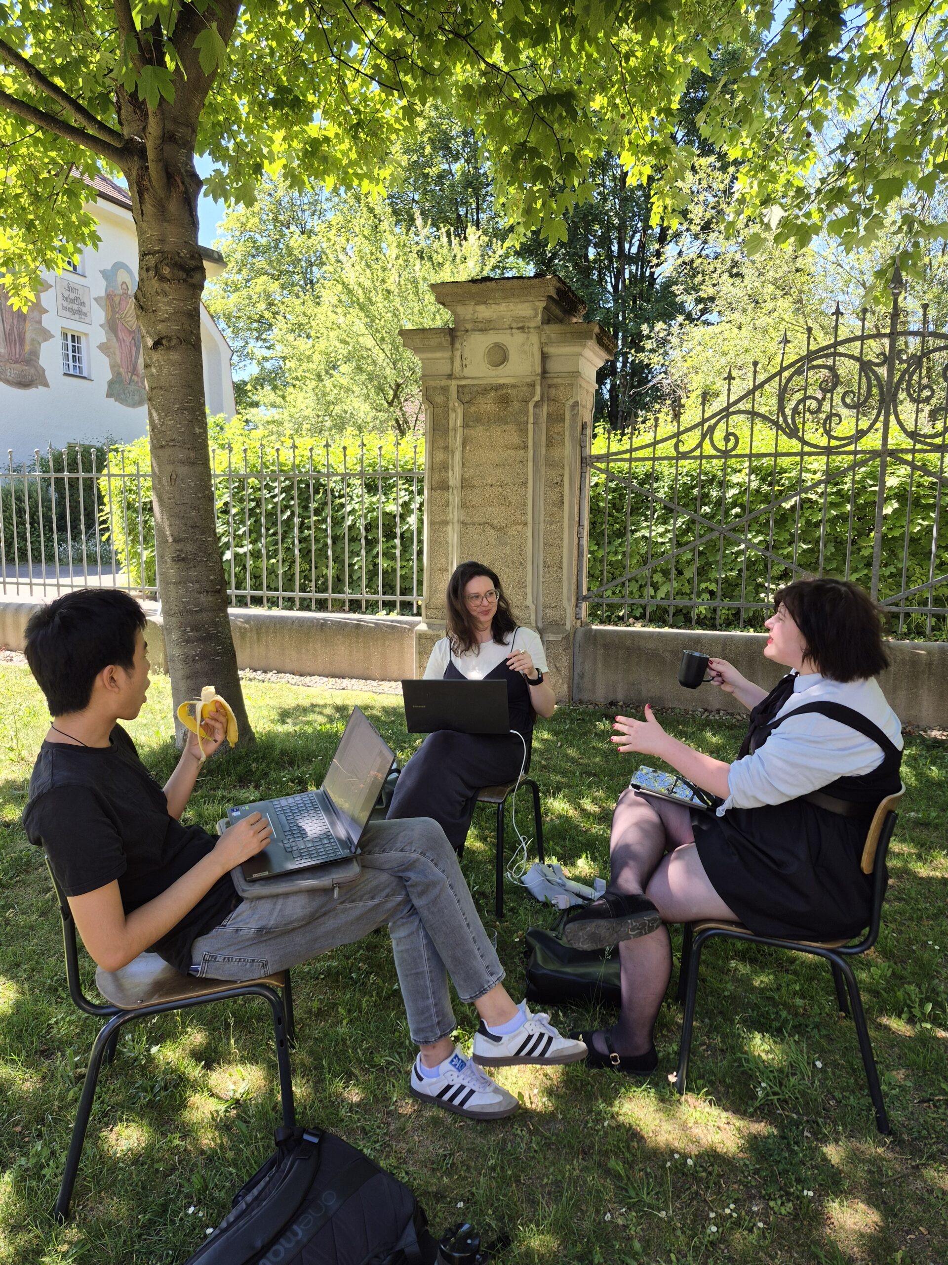 Auf diesem Bild sieht man die DCMs des Thementracks AI beim Arbeiten im Garten der Hochschule München.